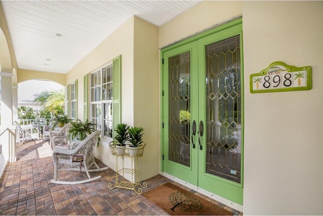 doorway to property with covered porch and french doors