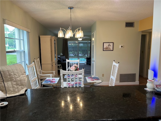 dining room featuring a textured ceiling and a notable chandelier