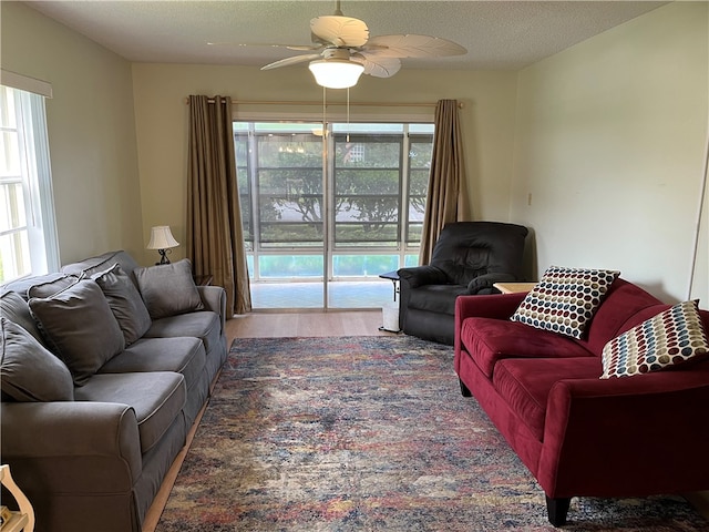 living room with hardwood / wood-style floors, ceiling fan, plenty of natural light, and a textured ceiling