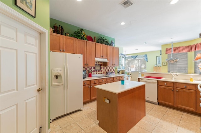 kitchen featuring white appliances, decorative light fixtures, a center island, and light tile patterned floors