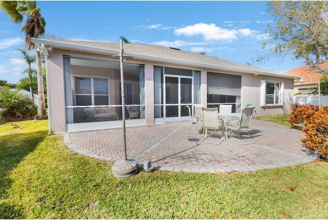 rear view of property with a patio, a sunroom, and a lawn