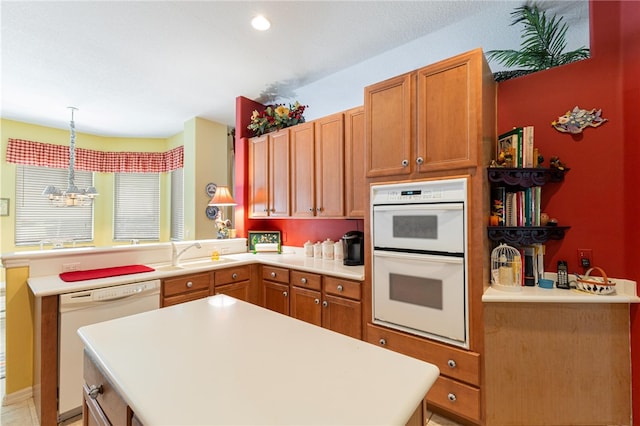 kitchen featuring an inviting chandelier, sink, pendant lighting, and white appliances