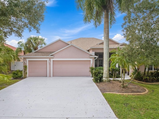 430 25th Ave SW, Vero Beach, FL 32962 - view of front of property featuring a garage, driveway, stucco siding, and roof with shingles