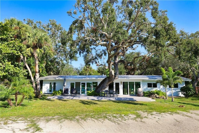 rear view of house with a patio and a lawn