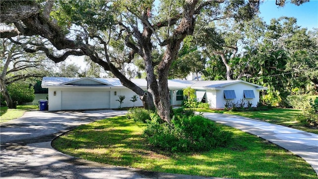 ranch-style home with a front yard and a garage