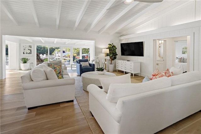 living room featuring ceiling fan, lofted ceiling with beams, and wood-type flooring