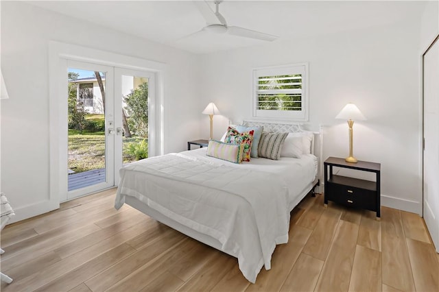 bedroom featuring ceiling fan, light wood-type flooring, multiple windows, and access to exterior