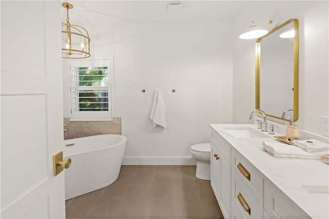 bathroom with a bath, toilet, tile patterned floors, vanity, and a chandelier