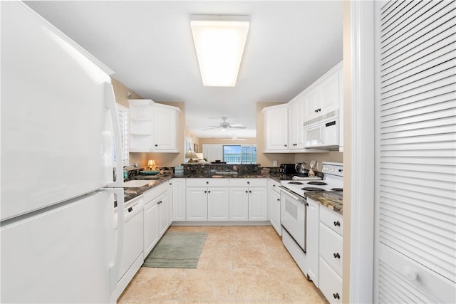 kitchen featuring dark stone countertops, sink, white cabinets, and white appliances