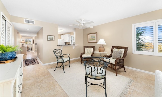 living area featuring ceiling fan and light tile patterned flooring