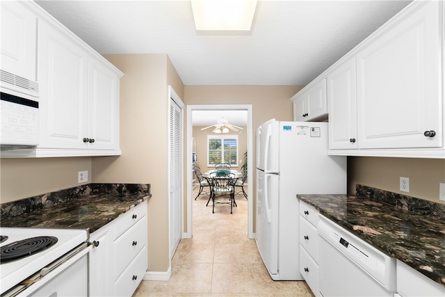 kitchen featuring white cabinets, light tile patterned floors, white appliances, and dark stone counters