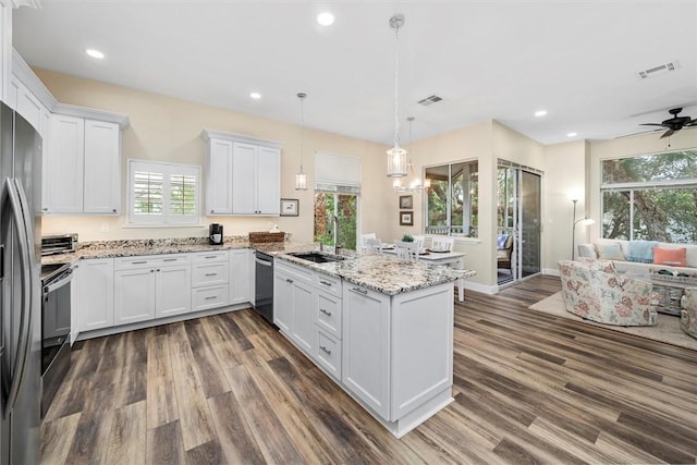 1335 Winding Oaks Cir E Unit 1007, Vero Beach, FL 32963 - kitchen featuring stainless steel appliances, a sink, a peninsula, dark wood-style floors, and white cabinetry