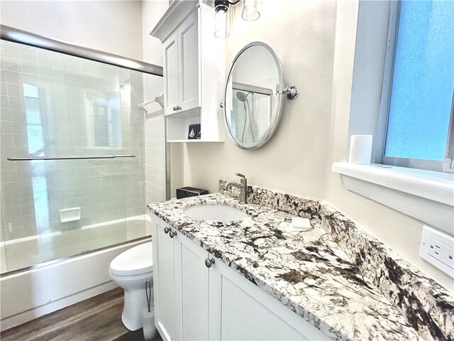 1335 Winding Oaks Cir E Unit 1007, Vero Beach, FL 32963 - bathroom with vanity, bath / shower combo with glass door, and wood finished floors