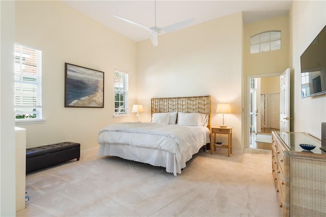 carpeted bedroom with multiple windows and a high ceiling