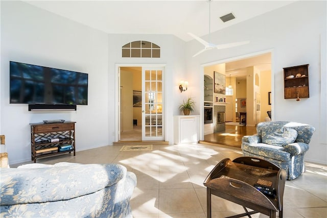 tiled living room featuring a fireplace and french doors