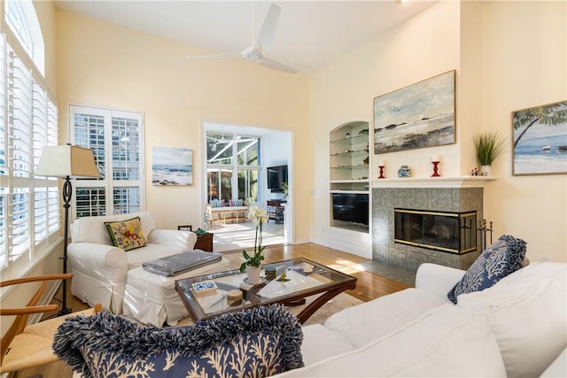 living room featuring hardwood / wood-style flooring, ceiling fan, a fireplace, and a wealth of natural light