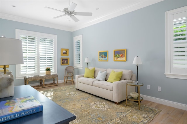 living room with baseboards, ornamental molding, wood finished floors, and a healthy amount of sunlight