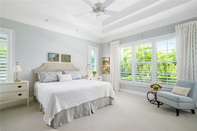 bedroom featuring light carpet, baseboards, a raised ceiling, ceiling fan, and crown molding