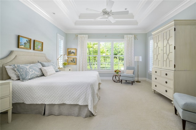 bedroom featuring ornamental molding, a tray ceiling, light carpet, and baseboards