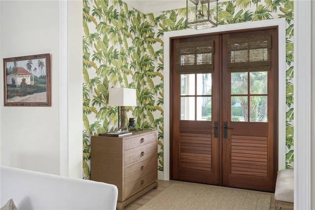 doorway to outside with wallpapered walls