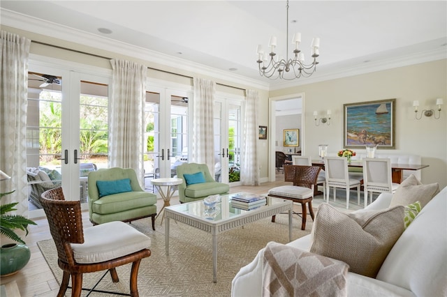 living area with a healthy amount of sunlight, wood finished floors, crown molding, and french doors