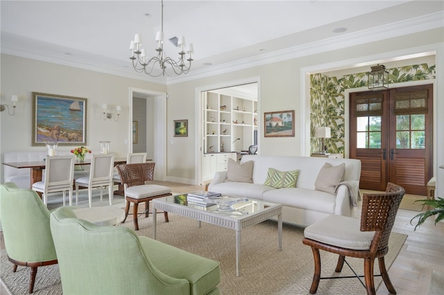 living area with a chandelier, light wood-style flooring, baseboards, ornamental molding, and french doors