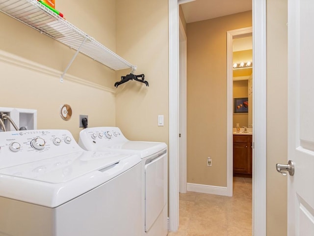 laundry area featuring light tile patterned flooring, sink, and washer and clothes dryer