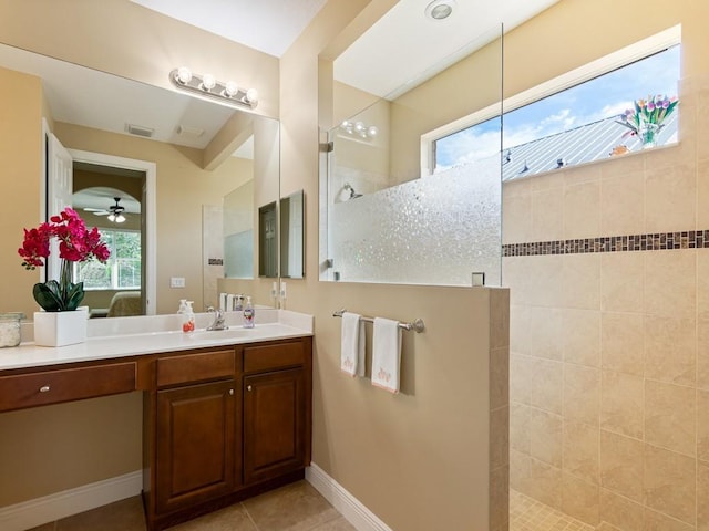 bathroom featuring ceiling fan, tile patterned floors, vanity, and a tile shower