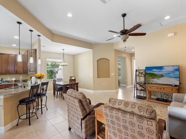 tiled living room featuring ceiling fan and sink