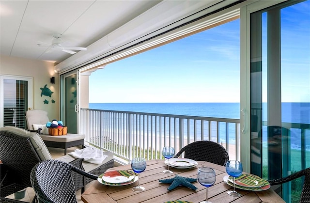 balcony with a water view, ceiling fan, and a view of the beach