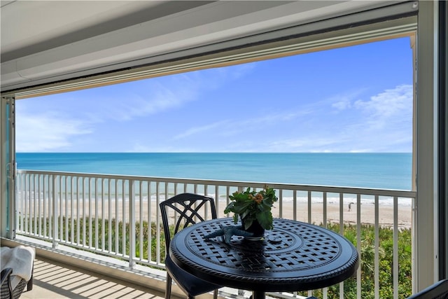 balcony featuring a water view and a view of the beach