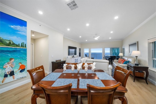 dining space featuring ceiling fan, ornamental molding, and light hardwood / wood-style floors