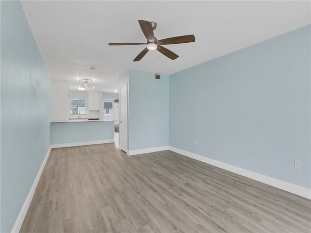 unfurnished living room with ceiling fan and light wood-type flooring