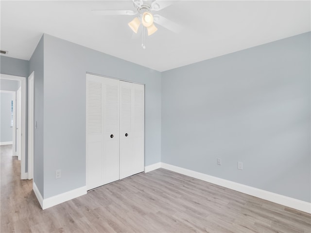 unfurnished bedroom featuring light wood-type flooring, a closet, and ceiling fan