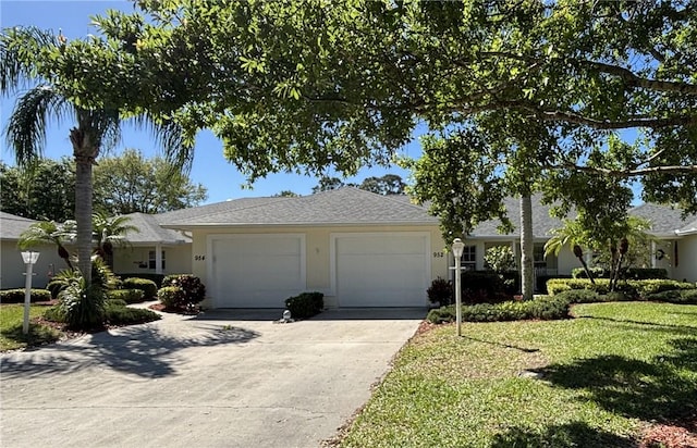 ranch-style home with a garage, a front yard, concrete driveway, and stucco siding