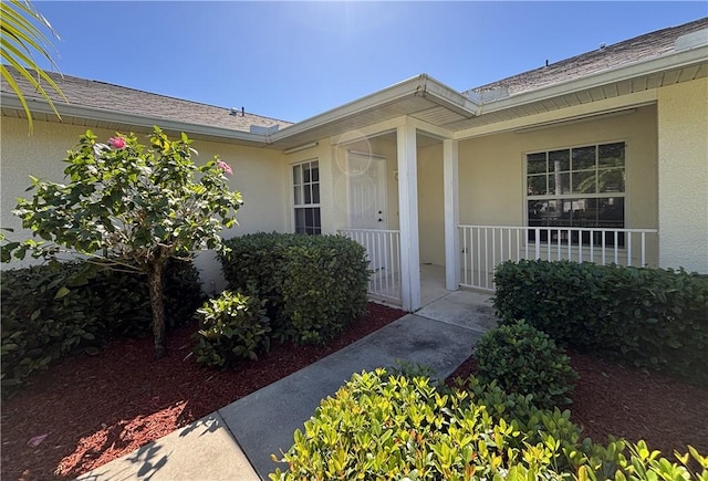 property entrance featuring a porch and stucco siding