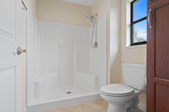 bathroom featuring tile patterned floors, toilet, and walk in shower