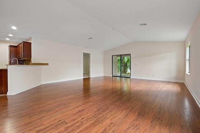 spare room with dark hardwood / wood-style flooring and lofted ceiling