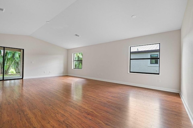 spare room with hardwood / wood-style floors and lofted ceiling