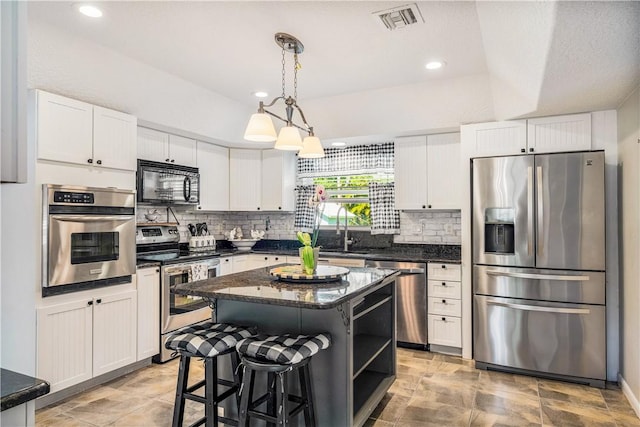 kitchen with white cabinets, stainless steel appliances, and a center island