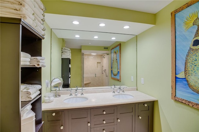 bathroom featuring a shower with door and vanity