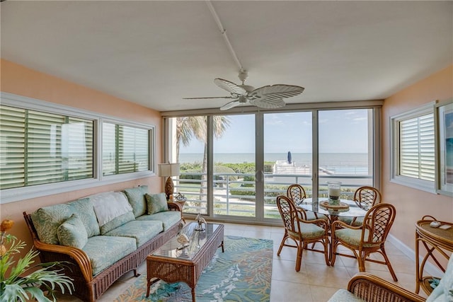 sunroom / solarium with ceiling fan and a water view