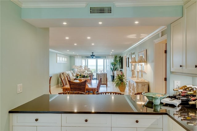 kitchen with ceiling fan, white cabinetry, crown molding, and kitchen peninsula