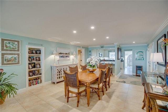 dining space with light tile patterned flooring, built in features, ornamental molding, and sink