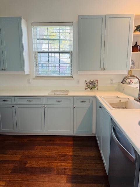 kitchen featuring dark wood-type flooring, a sink, light countertops, stainless steel dishwasher, and open shelves