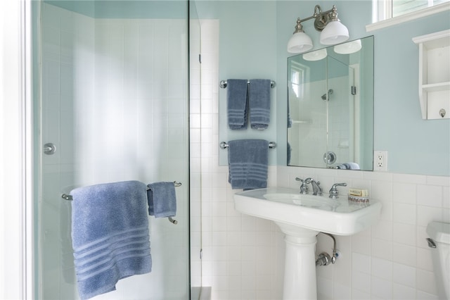 full bath featuring toilet, a shower stall, and tile walls