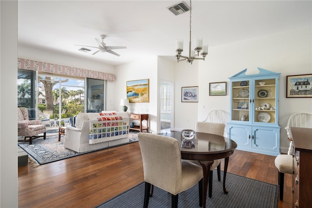 dining room with ceiling fan with notable chandelier, visible vents, and wood finished floors