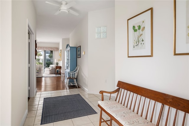 corridor with baseboards and light tile patterned flooring