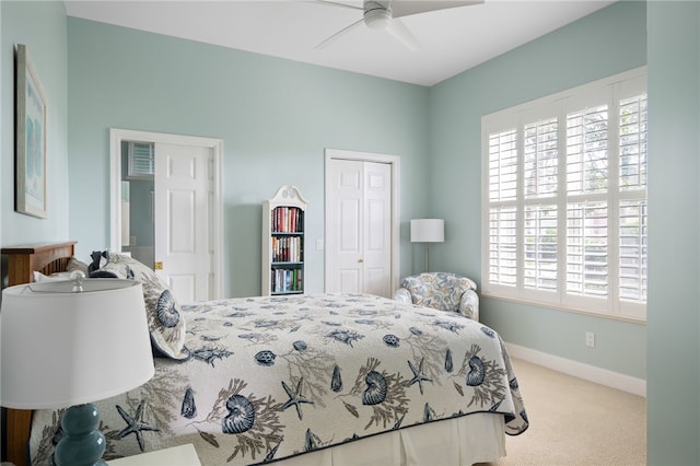 carpeted bedroom featuring a ceiling fan, a closet, and baseboards