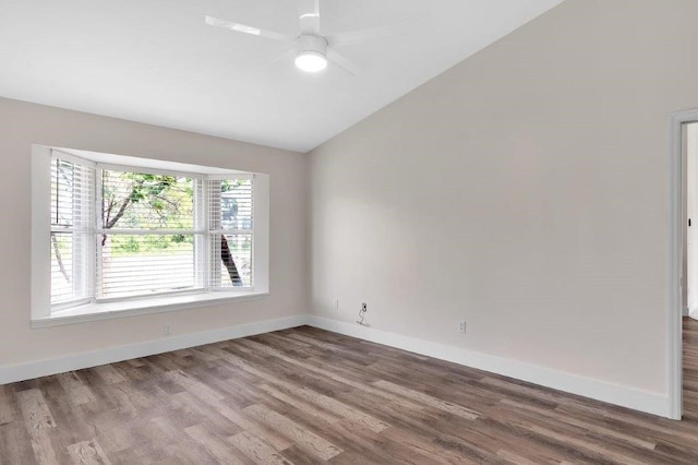 empty room with hardwood / wood-style flooring, vaulted ceiling, and ceiling fan